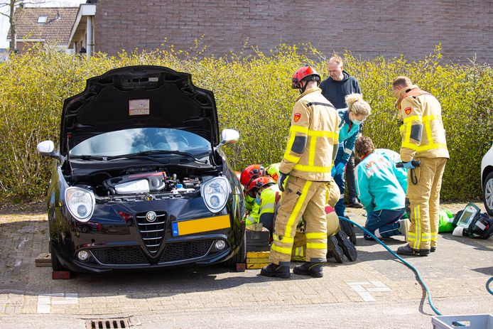 De man is door de brandweer onder de auto vandaag gehaald.