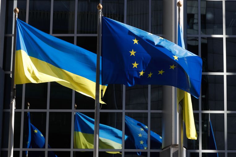 De Oekraïense en de Europese vlag naast elkaar aan het gebouw van het Europees Parlement in Brussel. Beeld EPA