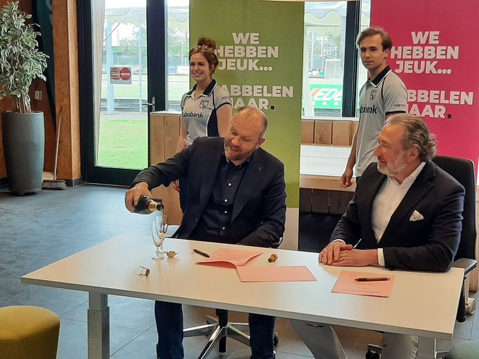Directeur Bert Bakkeren van Inofec en voorzitter Wim Vromans van HC De Pelikaan trekken de champagne open na het ondertekenen van het contract.