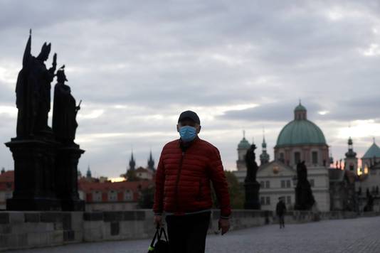 Een man met mondmasker op de beroemde Karelsbrug in de Tsjechische hoofdstad Praag. 