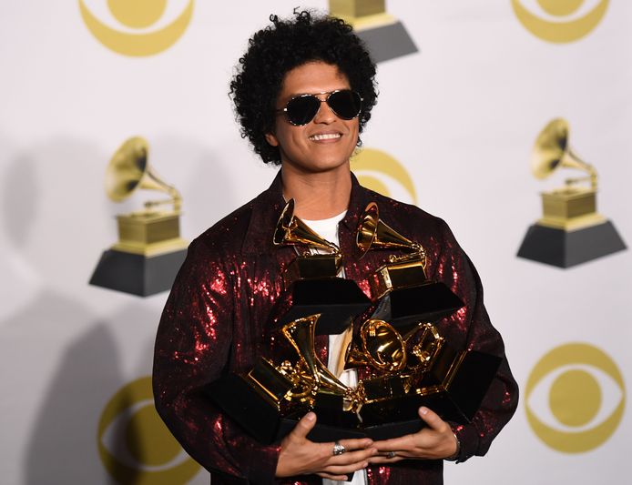 Bruno Mars poseert met twee armen vol Grammy's.