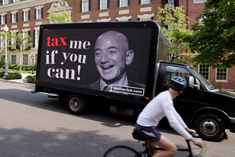 Een vrachtwagen van actiegroep Patriotic Millionaires rijdt langs één van de huizen van Jeff Bezos.  Beeld REUTERS