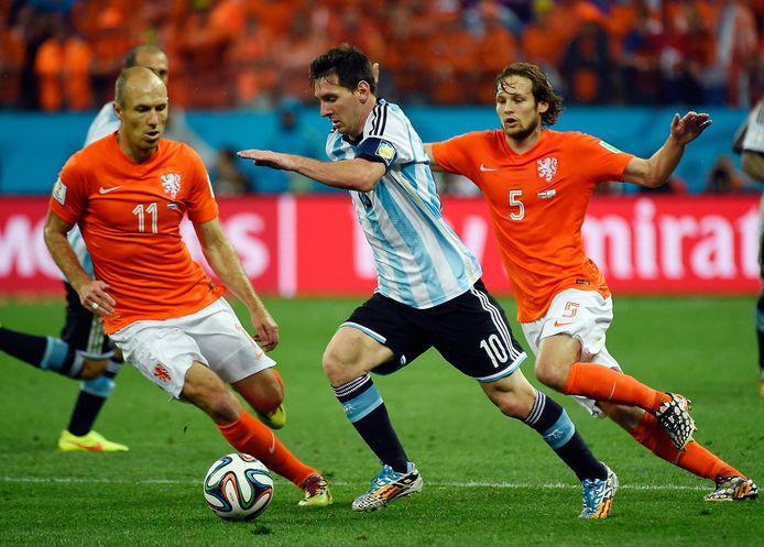 Lionel Messi dribbelt weg bij Arjen Robben en Daley Blind in de halve finale van het WK 2014 in de Corinthians Arena in São Paulo, waar Argentinië na strafschoppen met 4-2 won.