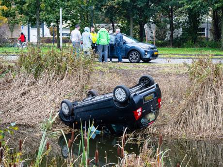 Auto vliegt uit de bocht en belandt op de kop in het water in Tilburg