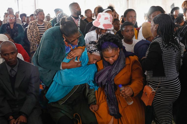 Familieleden tijdens een herdenkingsdienst voor de overleden jongeren.  Beeld AFP