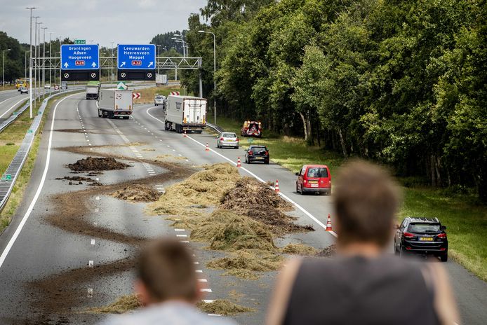 Voertuigen rijden langs hooi dat door boeren op de A28 gedumpt is. Nederlandse boerenactivisten demonstreren op meerdere plekken tegen het stikstofbeleid hun regering.