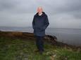 Henk Bos bij de Palendijk langs de kust  van Spakenburg. Aan de overkant Flevoland met windmolens. Daar zou hij graag een groter meer zien. ,,Het zijn tenslotte ónze oude visgronden.”