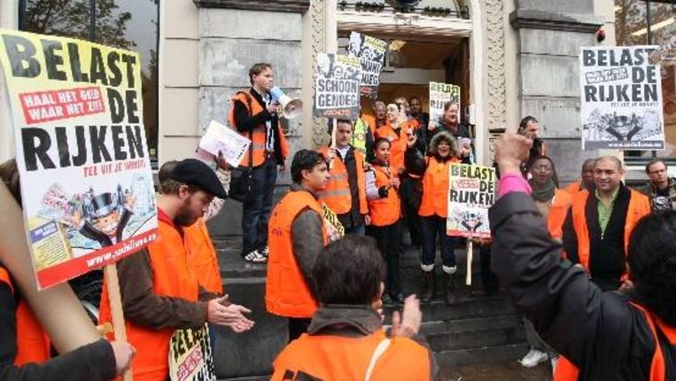 Schoonmakers voeren actie bij het hoofdkantoor van de PvdA in Amsterdam voor het behoud van de huidige AOW leeftijd. ( ANP) Beeld 