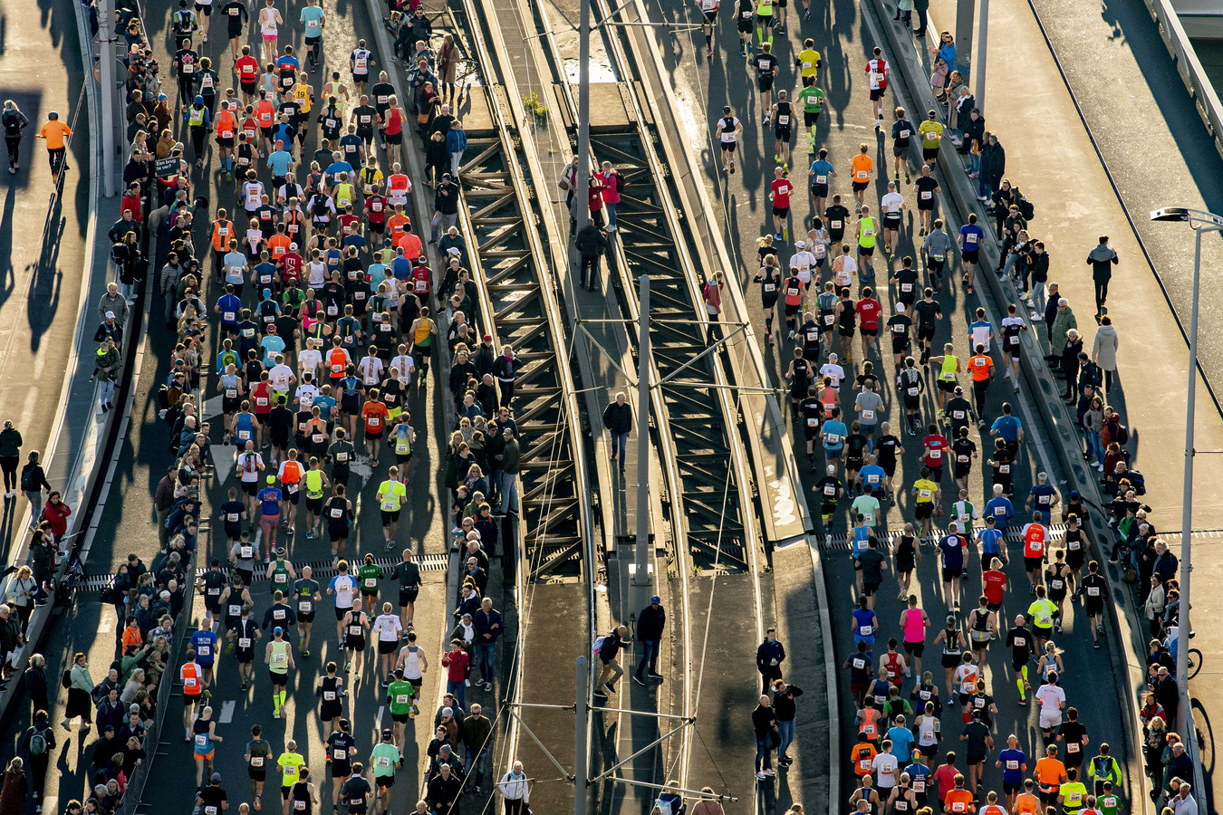 Deelnemers aan de Rotterdam Marathon gaan over de Erasmusbrug.