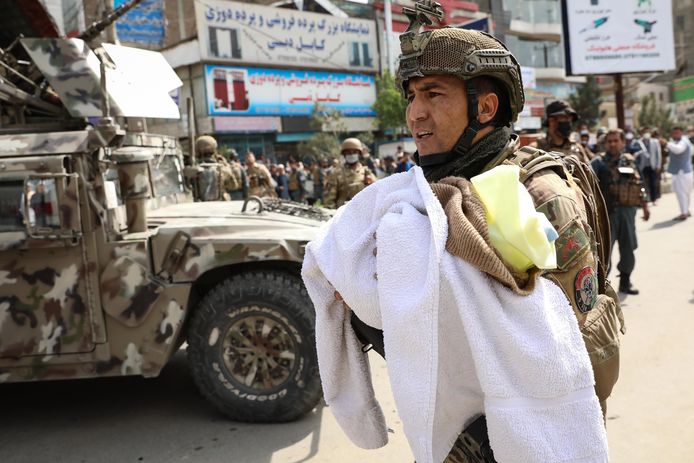 Een Afghaanse soldaat brengt een baby'tje in veiligheid na de aanslag op het ziekenhuis.