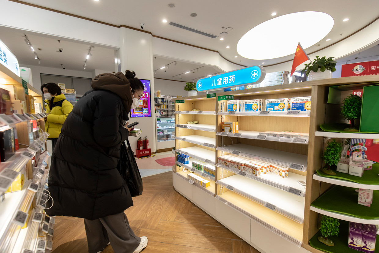 Een vrouw gaat in Shangai op zoek naar medicatie. Op veel plekken zijn de rekken met medicatie intussen bijna helemaal leeg. Beeld NYT