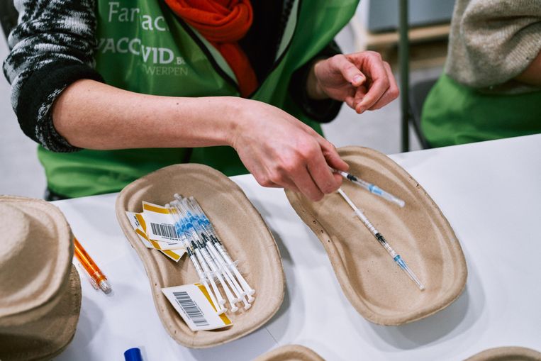 Een medewerker maakt spuiten klaar met een coronavaccin.  Beeld Thomas Sweertvaegher