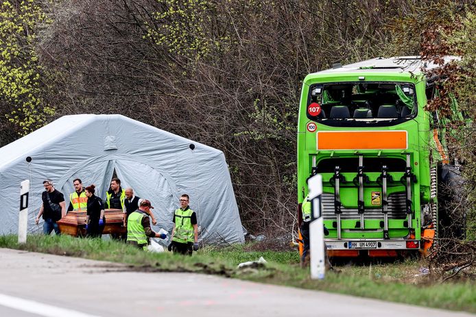 Een doodskist met het lichaam van een van de vier doden wordt weggedragen van de plek van het busongeluk op de A9 bij Leipzig.
