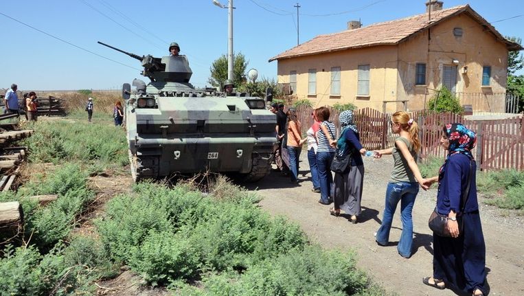 Een vredesdemonstratie, begin augustus, in de Turkse grensplaats Mardin, waar dit weekeinde twee Nederlanders werden opgepakt. Turkse soldaten kijken toe vanuit een pantservoertuig. Beeld afp