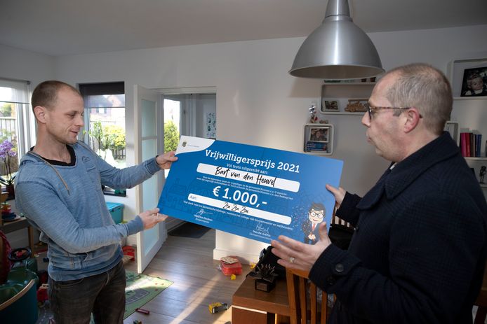 Winnaar van de Nuenense vrijwilligersprijs Bart van den Heuvel krijgt een cheque uitgereikt.