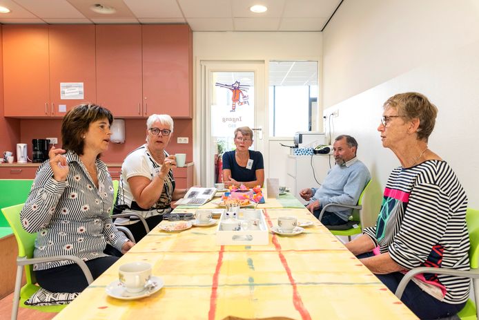 Vrijwilligers (links en midden) en bezoekers (rechts) gezellig aan de koffie bij de eerste keer 'Onder Mekaore' in Kruisland.