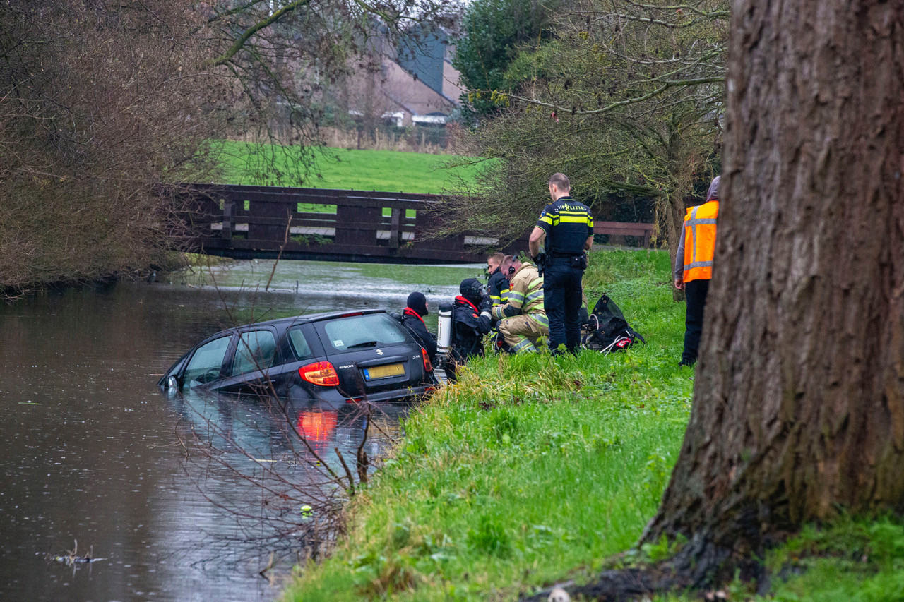 Hulpdiensten bij een auto te water in Mijdrecht. Daar, aan de Dukaton, redden twee stratenmakers eind vorig jaar het leven van een inzittende.