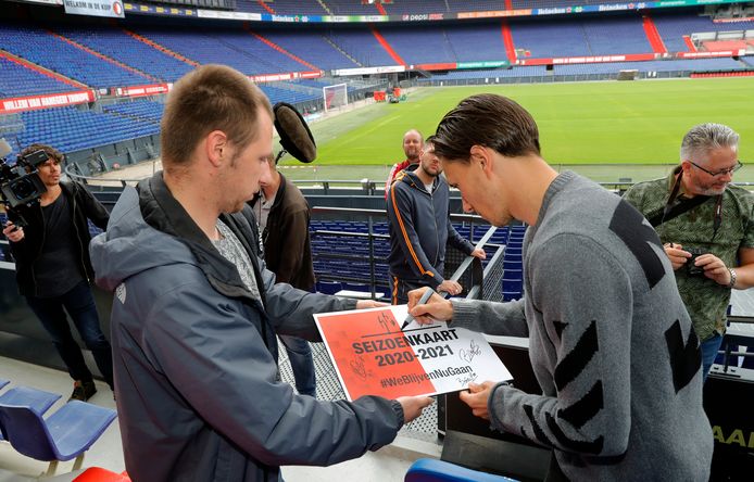 Steven Berghuis signeert de cheque voor een seizoenkaart die supporter Bradley de Graaf kreeg van de Feyenoordspelers.