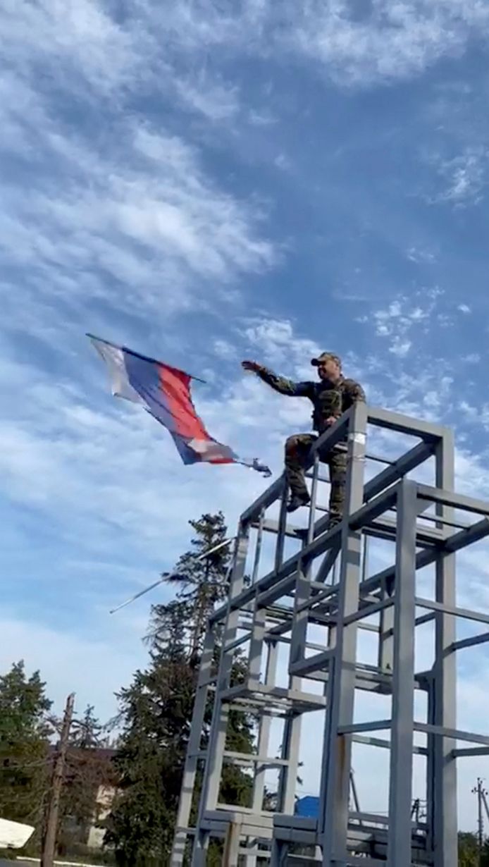 Een Oekraïense soldaat haalt de vlag van de 'republiek Donetsk' naar beneden in Lyman.