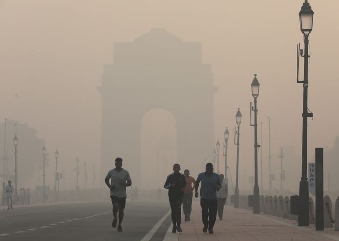 Enkele joggers tussen de zware smog in New Delhi.