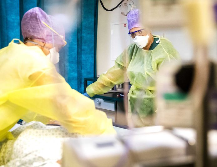 Zorgmedewerkers verlenen zorg aan een patiënt op de intensive care (IC) van een ziekenhuis.