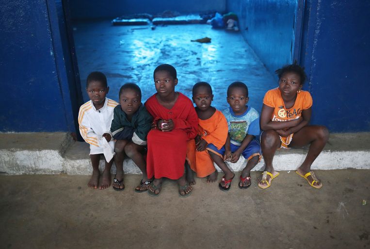 Kinderen op de drempel van een school in Monrovia, Liberia, die tot isolatieruimte voor met het ebolavirus besmette mensen is omgebouwd. Beeld Getty