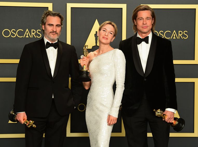Joaquin Phoenix (beste acteur), Renee Zellweger (beste actrice) en Brad Pitt (beste mannelijke bijrol) met hun Oscars.  Beeld AFP