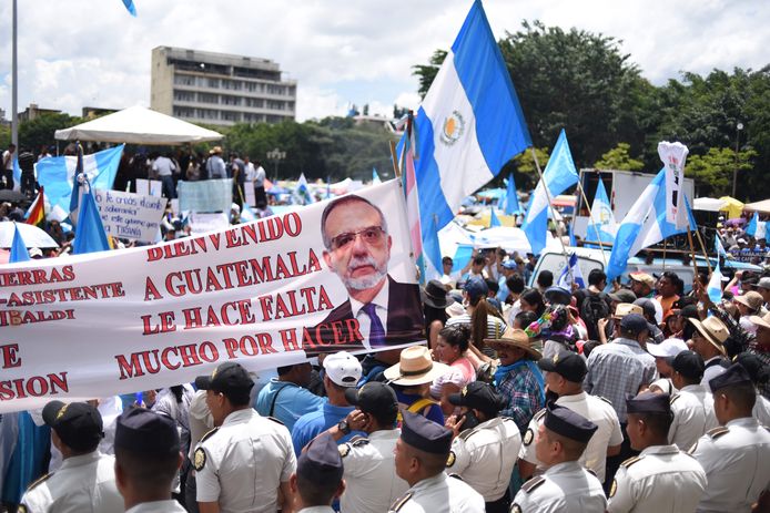 Betogers in Guatemala-Stad met een spandoek waarop het hoofd is afgebeeld van de Colombiaan Iván Velásquez, voorzitter van de Commissie tegen Corruptie en Straffeloosheid in Guatemala (Cicig), en de tekst 'Welkom in Guatemala, u bent nodig, nog veel te doen'.