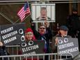Deze Amerikanen bij de rechtbank in New York protesteren juist tegen ex-president Donald Trump en vinden dat hij in de gevangenis hoort.