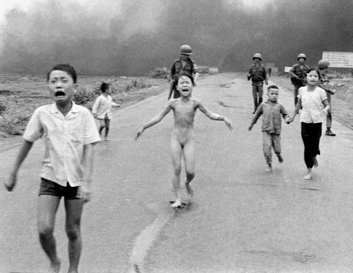 De negenjarige Kim Phuc probeert naakt weg te rennen van de napalm, die door haar huid brandt. Rechts van haar (links op de foto) haar twee broers, aan de andere kant haar neefje en nichtje.