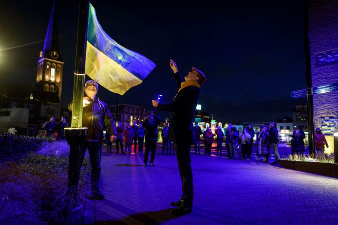 Burgemeester Sander Schelberg hijst samen met Johan Boonstra van Roesalka de Oekraïense vlag, terwijl de toren bij het stadhuis blauw en geel wordt uitgelicht.