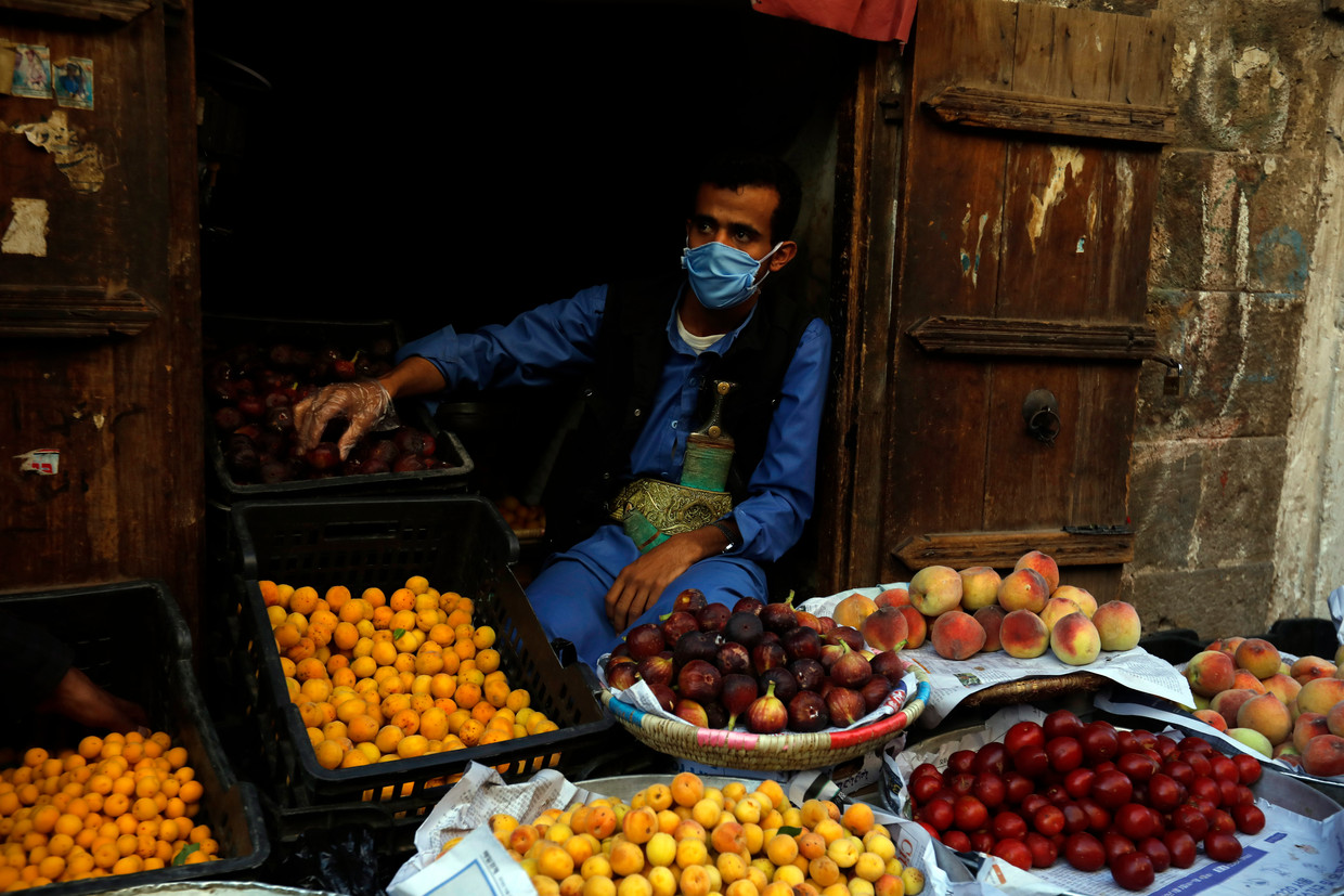 Een marktkoopman in Sanaa, Jemen, beschermt zich met een mondkapje. De kans op een wapenstilstand in Jemen is door de coronacrisis toegenomen. Beeld EPA