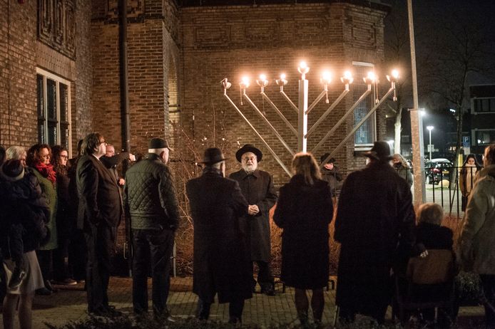 Rabbijn Jacobs (midden) heeft zaterdagavond de kaarsen ontstoken. Het is chanoeka en de kaarsen van de menora worden ontstoken voor de Synagoge aan de Prinsenstraat.