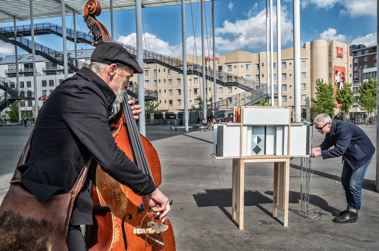 Kunstenaar Benjamin Verdonck en bassist Tomas De Smet entertainen voorbijgangers op het Theaterplein in Antwerpen. Beeld Tim Dirven