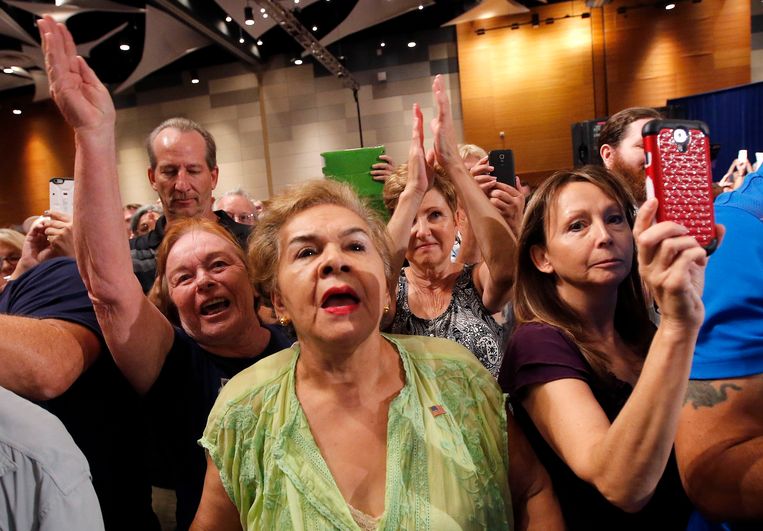 Aanhangers van Trump begroeten de miljardair zaterdag tijdens een drukbezochte bijeenkomst in Phoenix. Beeld ap