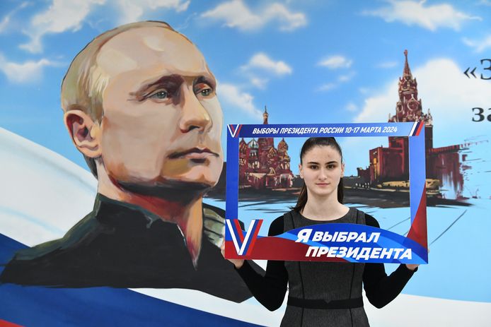 Een vrouw poseert voor Vladimir Poetin met het bord 'Ik heb gestemd op een president'.