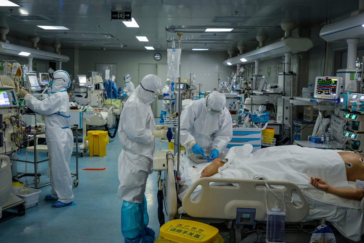 Beeld uit de begintijd van de covidpandemie: ic-personeel in het Chinese Wuhan ontfermt zich over covidpatiënten, februari 2020. Beeld FeatureChina / AP
