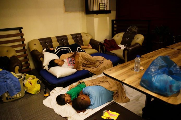 Inwoners uit de Filipijnse stad Tuguegaroa slapen in een hotel nadat hun huizen deels zijn vernietigd door de tyfoon Manghkut.