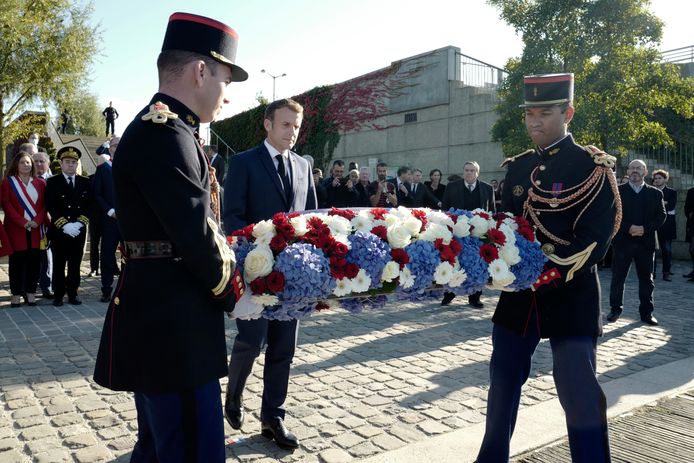 De Franse president Emmanuel Macron legt bloemen neer als eerbetoon aan de slachtoffers van de Algerijnse manifestatie (AP Photo/Rafael Yaghobzadeh, Pool)