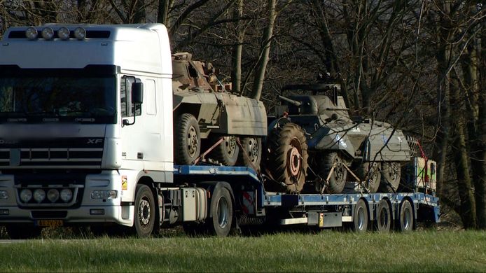 De vrachtwagen met twee pantservoertuigen op de afrit naast de A2.