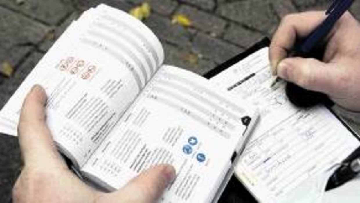Een agent schrijft een bekeuring. (LEX VAN LIESHOUT, ANP ) Beeld 