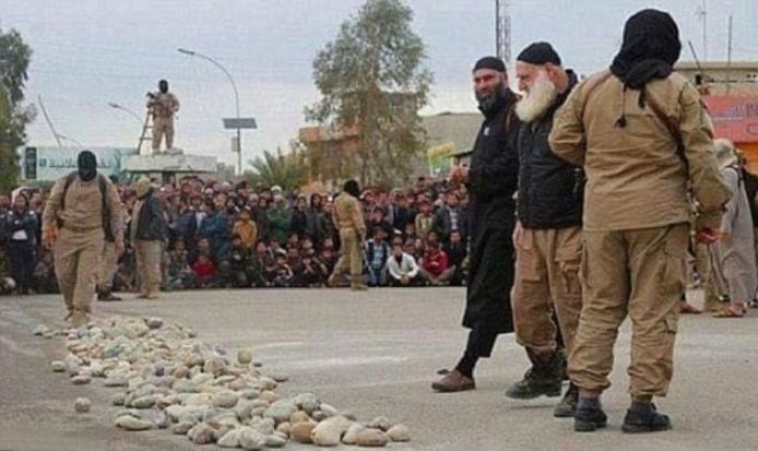 De man met witte baard, geïdentificeerd als Abu Omer, kijkt naar een hoop stenen vooraleer over te gaan tot de openbare executie.