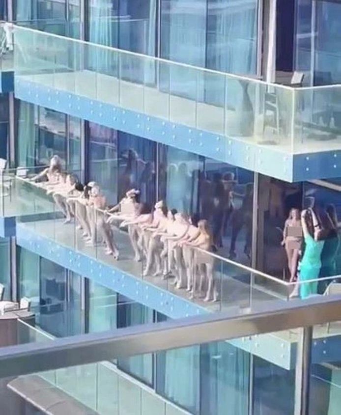 Een lange rij dames staat poedelnaakt aan een balustrade van een wolkenkrabber in Dubai, terwijl een ander deel binnen pornomateriaal maakt. De grofweg 40 vrouwen uit Wit-Rusland, Moldavië en Oekraïne riskeren zes maanden gevangenis en hoge boetes.