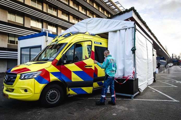 Een ambulance bij een portakabin bij de spoedeisende hulp van het Groene Hart Ziekenhuis in Gouda. Op deze plek worden patiënten opgevangen van wie wordt vermoed dat zij corona hebben of die het virus daadwerkelijk onder de leden hebben. Hierdoor kunnen de stromen patiënten met en zonder corona worden gescheiden.