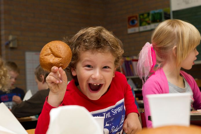 Een leerling is blij met een bruine bol tijdens het Nationaal Schoolontbijt.