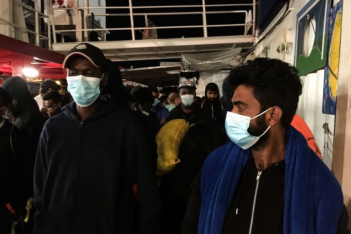Migranten dragen beschermende mondkapje aan boord van de Ocean Viking.