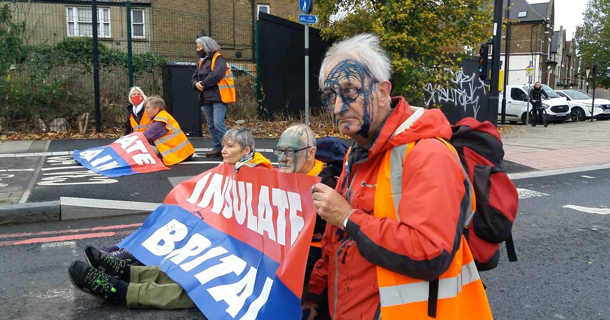 I manifestanti per il clima bloccano le strade trafficate di Londra mentre passanti arrabbiati spruzzano inchiostro blu sui loro volti |  uno sconosciuto