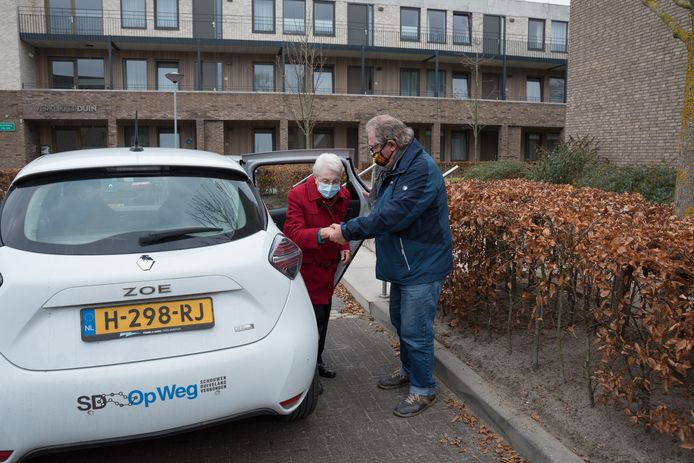 Chauffeur Bob van der Valk helpt Jo van Elswijk uit Renesse uit de elektrische buurtauto. Hij rijdt haar rond voor boodschappen en een bezoekje aan Duinen van Haamstede en brengt haar weer terug.