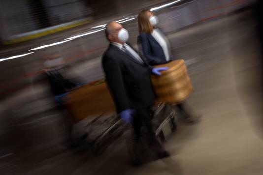 (archieffoto) Begrafenisondernemers in Barcelona dragen de kist van een Covid19-slachtoffer naar de lijkwagen.