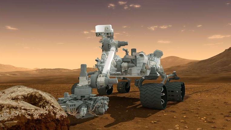 Impressie van de onderzoeksrobotwagen Curiosity aan het werk op Mars. Beeld afp